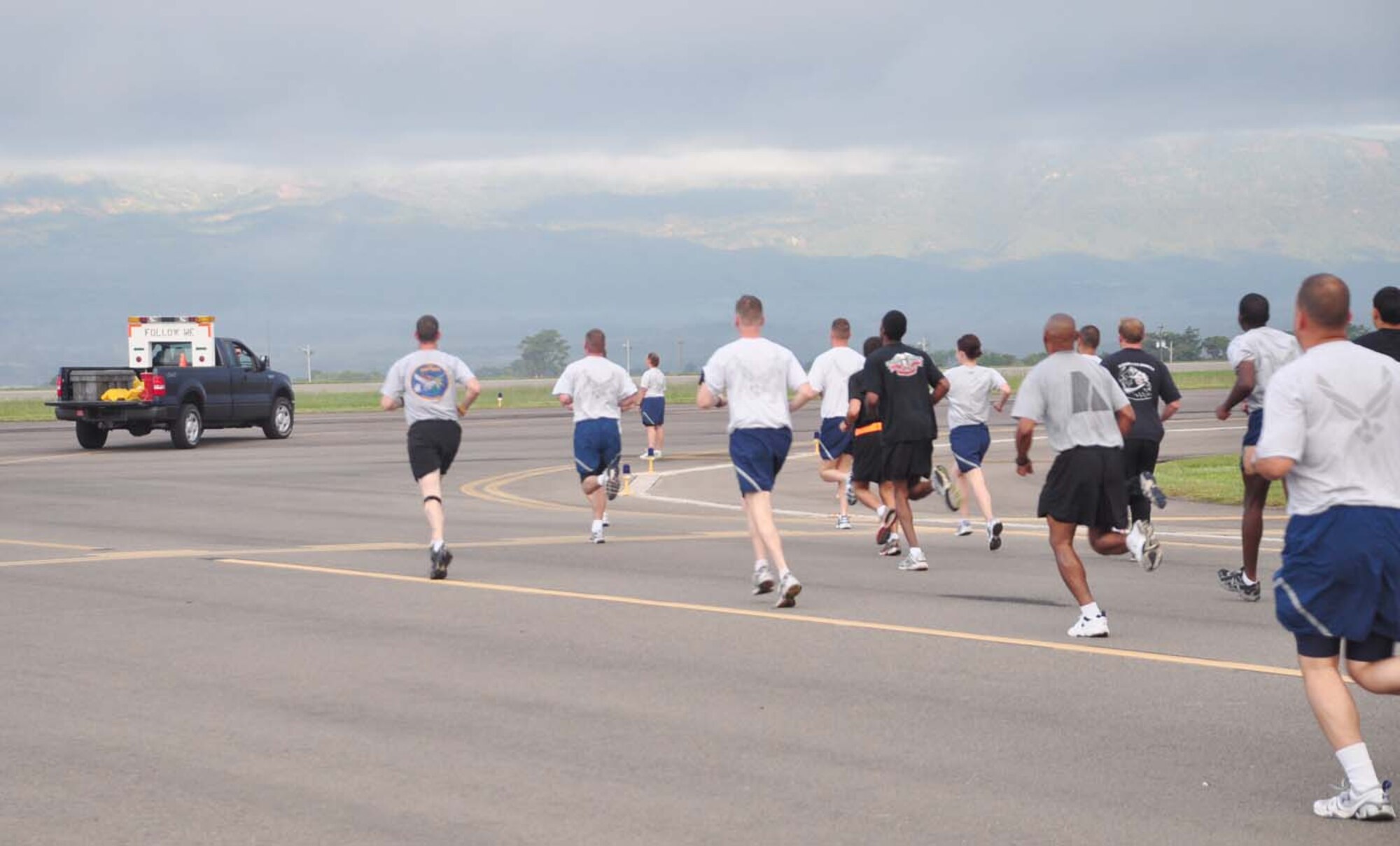 SOTO CANO AIR BASE, Honduras — Runners make the first turn onto the active runway following the airfield operation’s “follow me” truck during the Air Force's 62nd birthday celebration 5k run here Sept. 18.  About 175 Soldiers, Sailors and Airmen participated in the 5k run around the base runway (U.S. Air Force photo/Staff Sgt. Chad Thompson).