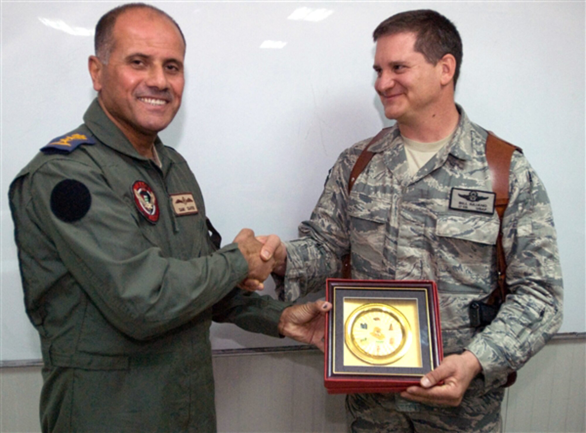 Iraqi air force Col. Sami shakes hands with Lt. Col. Bill Iuliano during a brief ceremony Sept. 14, 2009, at Contingency Operating Base Basra, Iraq. The two officers flew on opposite sides of the Persian Gulf War in 1991, but have worked together in Operation Iraqi Freedom to strengthen the Iraqi air force. (U.S. Army photo/Sgt. Frank Vaughn) 