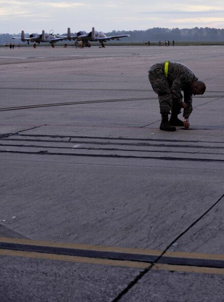 MOODY AIR FORCE BASE, Ga. -- Staff Sgt. Dominick Della-Pia, 23rd Fighter Group intelligence analyst, picks up foreign object debris from the flightline during a foreign object debris walk here Sept. 18. Airmen searched for loose rubble, trash, lost items and any other materials that did not belong on the flightline. (U.S. Air Force photo by Senior Airman Schelli Jones)