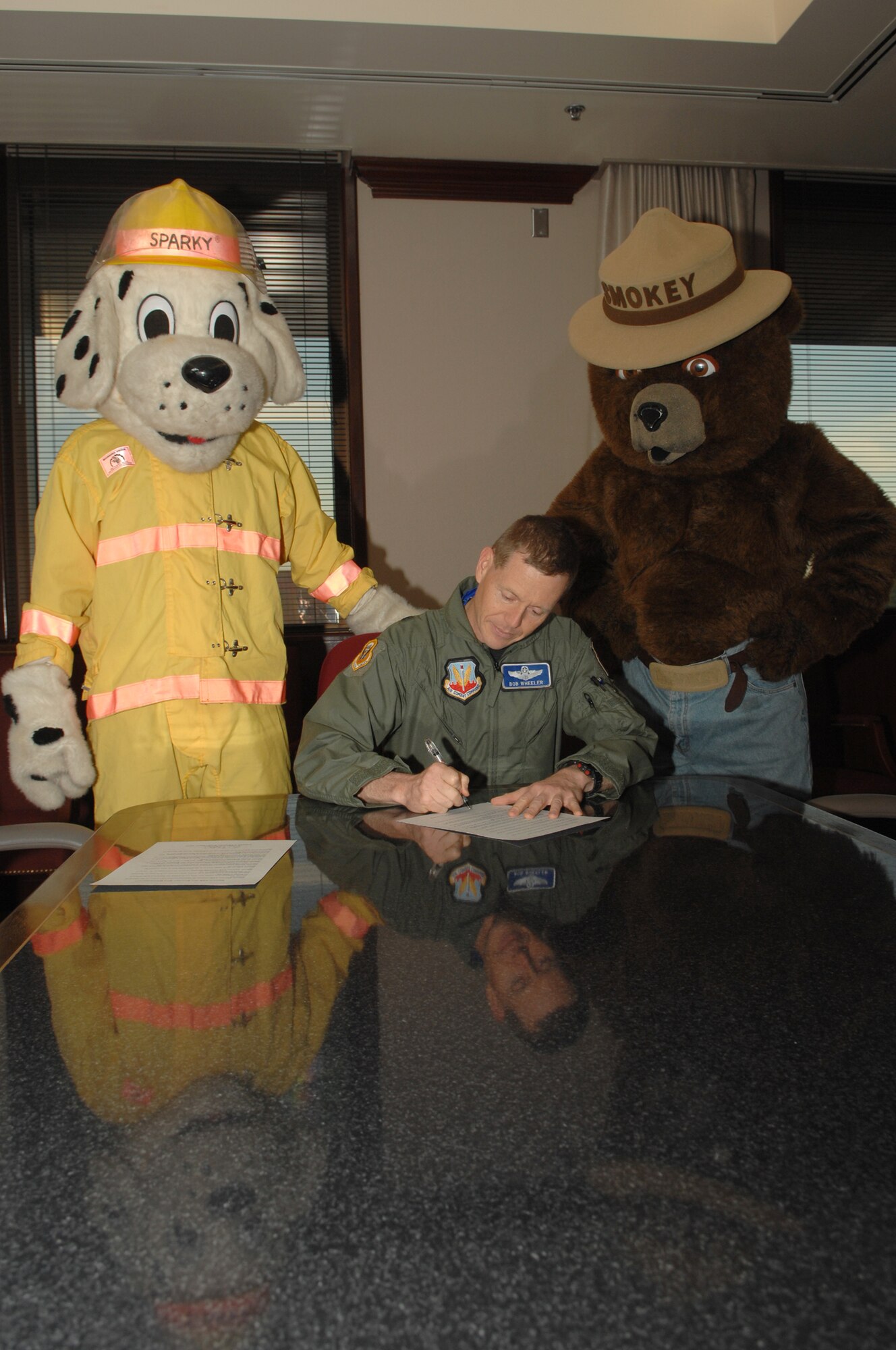 WHITEMAN AIR FORCE BASE, Mo. -- Sparky the Dog and Smokey the Bear watch as Brig. Gen. Robert Wheeler, 509th Bomb Wing commander, signs a Fire Prevention Week document Sept. 18.  Fire Prevention Week begins Oct. 4 and ends Oct 10th.   (U.S. Air Force photo/Senior Airman Jessica Snow)