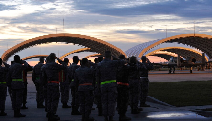 MOODY AIR FORCE BASE, Ga. -- 23rd Wing Airmen salute during the playing of reveille before performing a foreign object debris walk in preparation for the upcoming Operational Readiness Inspection here Sept. 18. The purpose of the FOD walk is to remove debris from the flightline.  (U.S. Air Force photo by Senior Airman Schelli Jones)