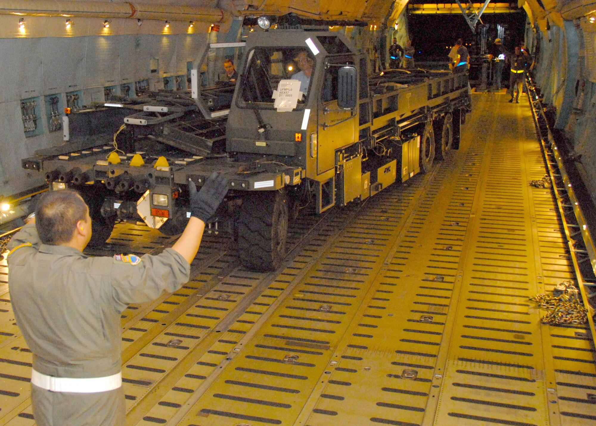 Nightime made no difference as aircraft loading continued, a "K-loader" is maneuvered inside a C-5, 908th mobility bags are pulled from storage and prepared for loading, a portable heater and electric generator are positioned and 908th members ensure a cargo pallet is securely fastened. (U.S. Air Force photo/Jamie Pitcher)
