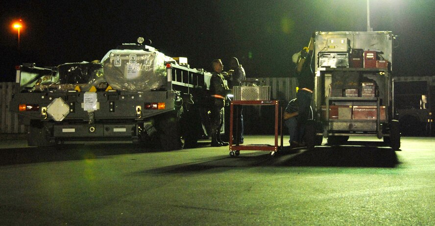 Nightime made no difference as aircraft loading continued, a "K-loader" is maneuvered inside a C-5, 908th mobility bags are pulled from storage and prepared for loading, a portable heater and electric generator are positioned and 908th members ensure a cargo pallet is securely fastened. (U.S. Air Force photo/Jamie Pitcher)
