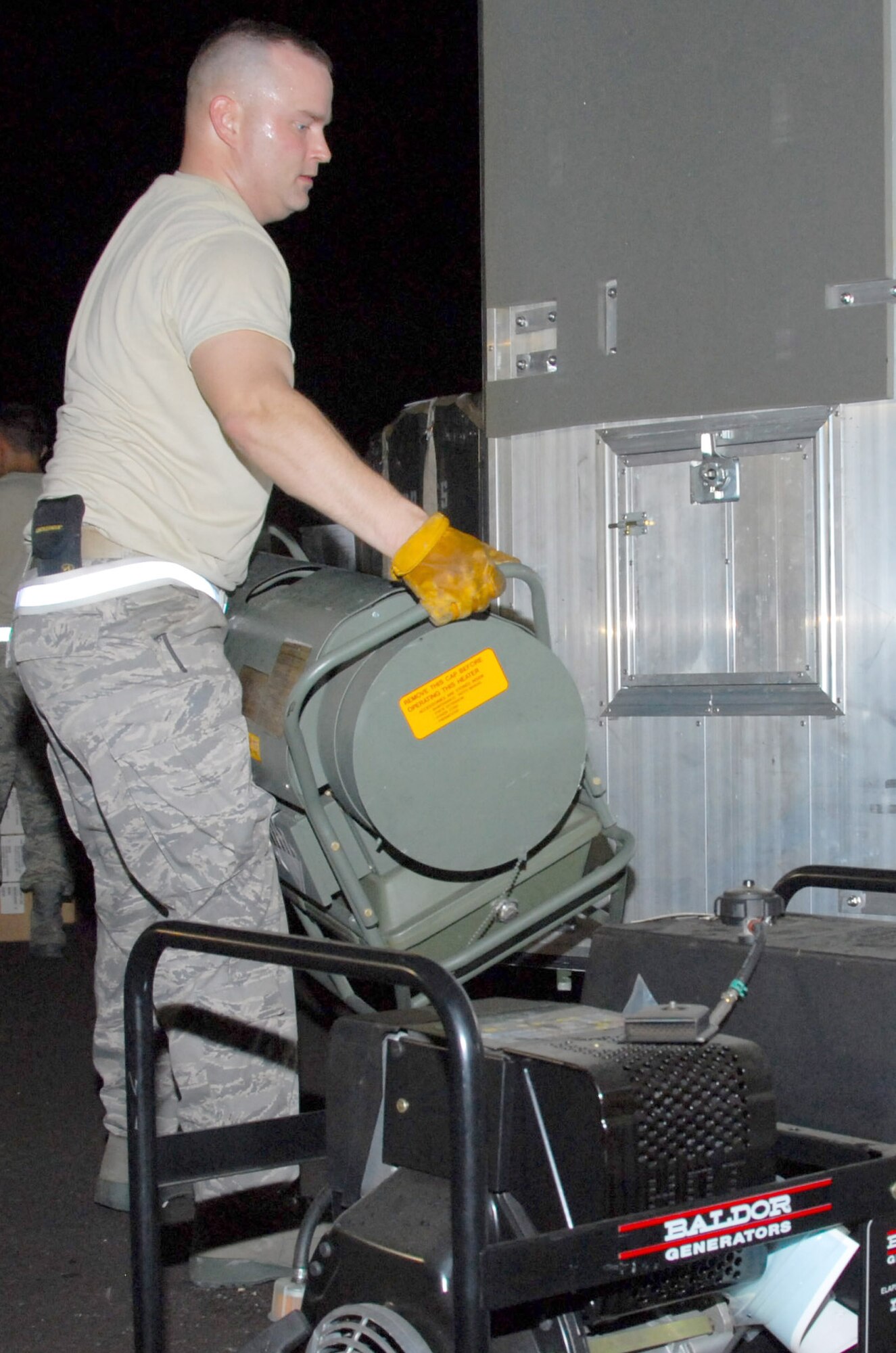 Nightime made no difference as aircraft loading continued, a "K-loader" is maneuvered inside a C-5, 908th mobility bags are pulled from storage and prepared for loading, a portable heater and electric generator are positioned and 908th members ensure a cargo pallet is securely fastened. (U.S. Air Force photo/Jamie Pitcher)
