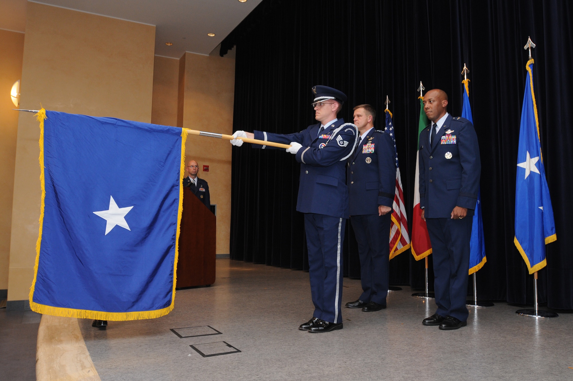 Lt. Gen. Frank Gorenc, 3rd Air Force commander, Ramstein Air Base, Germany (back left) and Brig. Gen. Charles Q. Brown Jr., 31st Fighter Wing commander look on as a member of the base honor guard detail unfurls the one-star flag during his promotion ceremony Sept. 18, 2009 at Aviano Air Base, Italy.  General Gorenc presided over the ceremony.   (U.S. Air Force photo/Staff Sgt. Patrick Dixon) 