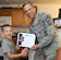 Braiden Spangler, 7, son of Special Agent Christopher Spangler, Office of Special Investigations Det 1, is honored by Chief Master Sgt. John Gillette, 305th Air Mobility Wing command chief, on behalf of United Communities here recently. Braiden responded to a request from UC asking for donations for children in schools and orphanages in Djibouti, Africa. Braiden broke his piggy bank to give all he had and two large bags of his own clothes to help others in need. UC will continue to accept donations to be sent to the children. (U.S. Air Force photo/Wayne Russell)