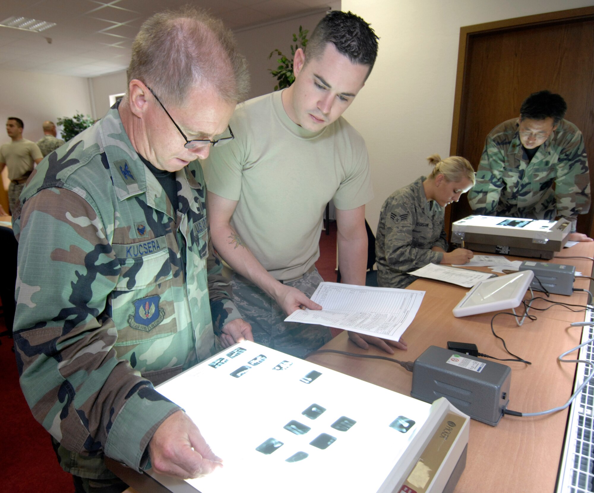 SPANGDAHLEM AIR BASE Germany – 52nd Dental Squadron Commander, Col. (Dr.) Michael Kucsera, and Senior Airman Joshua Barnes, an oral preventative assistant, review patient dental X-ray records to identify victims of a simulated plane crash.  Both took part in a forensics exercise during the Air Force Oral Pathology and Forensics Conference at the Eifel Wilkommen Center Sept. 18.  This two-day conference was attended by Air Force and Army dentists and dental technicians.  (U.S. Air Force photo/Master Sgt. Bill Gomez)