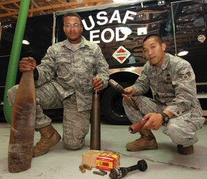 Staff Sgt. Michael Dove, 316th Civil Engineer Squadron Explosive Ordnance Detachment NCO in charge of operations, and Senior Airman Johnny Mai, 316 CES EOD supply journeyman, display ordnance found at a residence in Carroll County, Md., during a recent mission. (U.S. Air Force photo/ Bobby Jones)