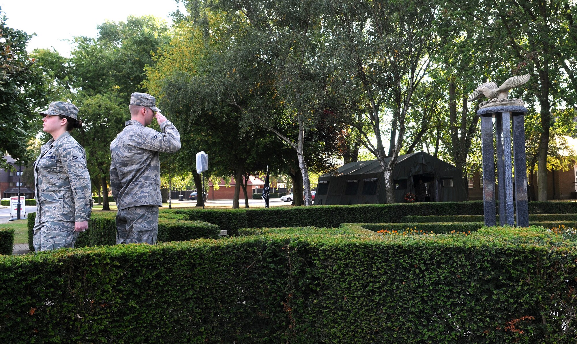 RAF MILDENHALL, England -- Senior Airman Ian Voelkel, 100th Aircraft Maintenance Squadron, salutes the Prisoner of War/Missing in Action war memorial here before relieving Senior Airman Melanie Marquez, 488th Intelligence Squadron, of duty Sept. 17. These volunteers were part of a 24-hour vigil in observance of POW/MIA remembrance week. They listed the names of servicemembers still MIA and guarded the memorial.  (U.S. Air Force photo/Senior Airman Thomas Trower)