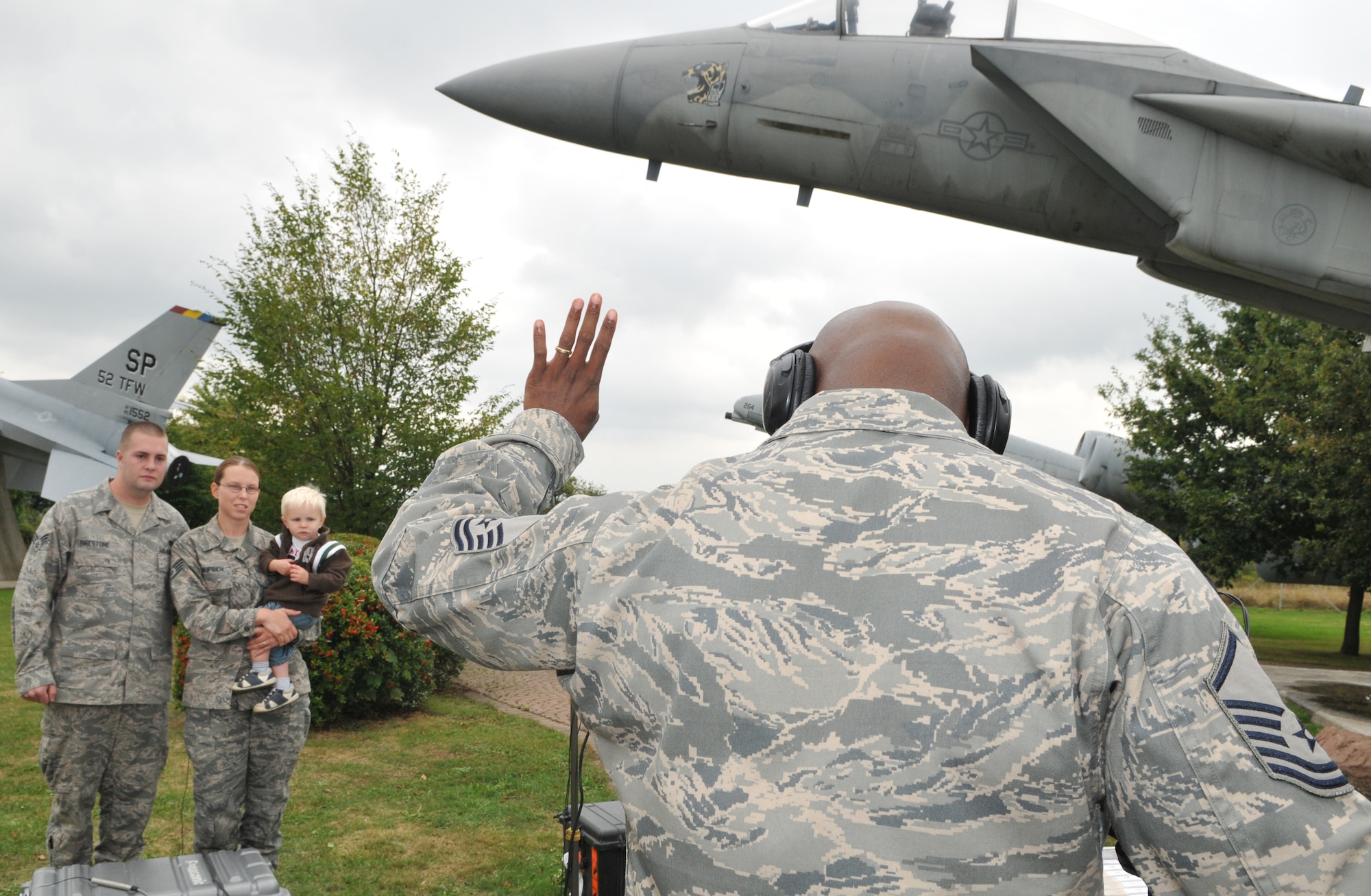 SPANGDAHLEM AIR BASE, Germany -- Master Sgt. Antonio Propst, Joint Hometown News Team, records Senior Airman Mason Firestone and Staff Sgt. Elizabeth Hauprich, both 52nd Component Maintenance Squadron, and their son, Joseph’s, Holiday Hometown news greeting at the Spangdahlem Air Base Air Park Sept. 15. A three-man team from Defense Media Activity located in San Antonio, Texas, recorded holiday greetings of military members and their families across Europe for their loved ones in the United States. People who recorded holiday greetings can expect them to be aired after Nov. 23. The team recorded 200 messages here.  (U.S. Air Force photo/Airman 1st Class Nick Wilson)