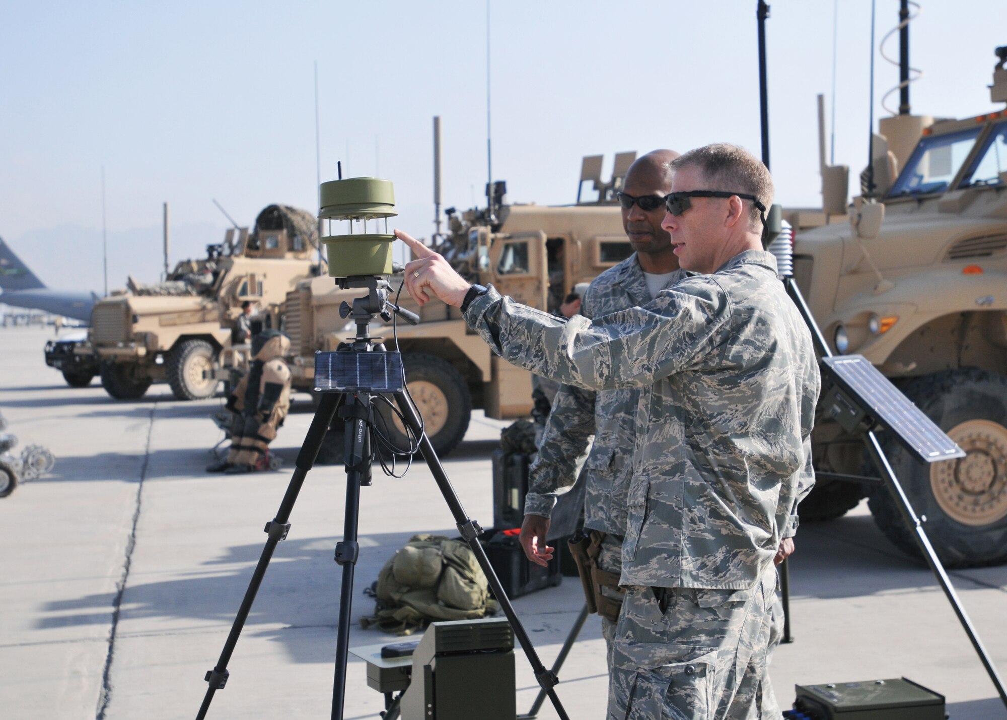 BAGRAM AIRFIELD, Afghanistan -- Lt. Col. Brian Griffith, 19th Expeditionary Weather Squadron commander, discusses battlefield weather capabilities with Capt. Jacob Chisolm, 504th Expeditionary Air Operations Support Group executive officer at the Air Force's 62nd birthday here Sept. 18, 2009.   The Air Force birthday events started at 6 a.m. with a military formation of hundreds of Airmen, Soldiers, Sailors and Marines, reville, a five kilometer run and was later followed by a ceremony and open house with many Air Force aircraft on display.  The open-house event was held for Soldiers, Marines and Sailors to get more acquainted with their Air Force counterparts who are often providing support from the sky, or from remote bases scattered across Afghanistan.  U.S. Army Chief Warrant Officer-3 James Wright, from the 101st Airborne said: "This was a great opportunity for me to view Airmen and their aircraft.  Airmen are doing a great for our Forward Operating Bases and helping our troops in the mountains.  The Army is proud of you guys."  (U.S. Air Force photo/Capt. David Faggard)
