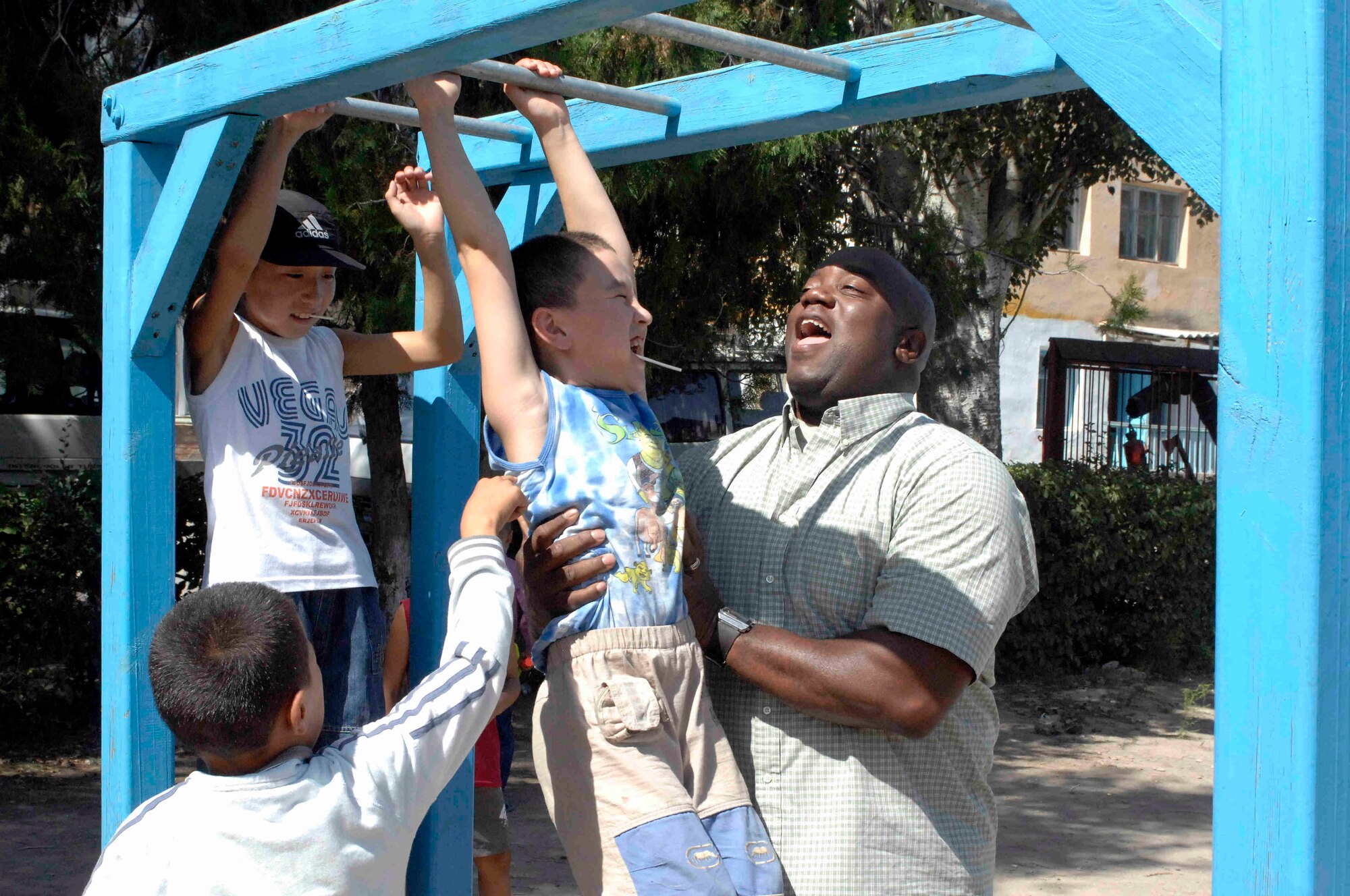 NIZHANCHUISK VILLAGE, Kyrgyzstan -- The youngest student rings a bell while carried by another student, at the Nizhanchuisk School, marking the start of the new school year, Sept. 8, 2009. Airmen from the Transit Center at Manas were invited to share in the ceremony of music and tradition marking the new school year. (U.S. Air Force photo/Senior Master Sgt. Andrew Lynch)