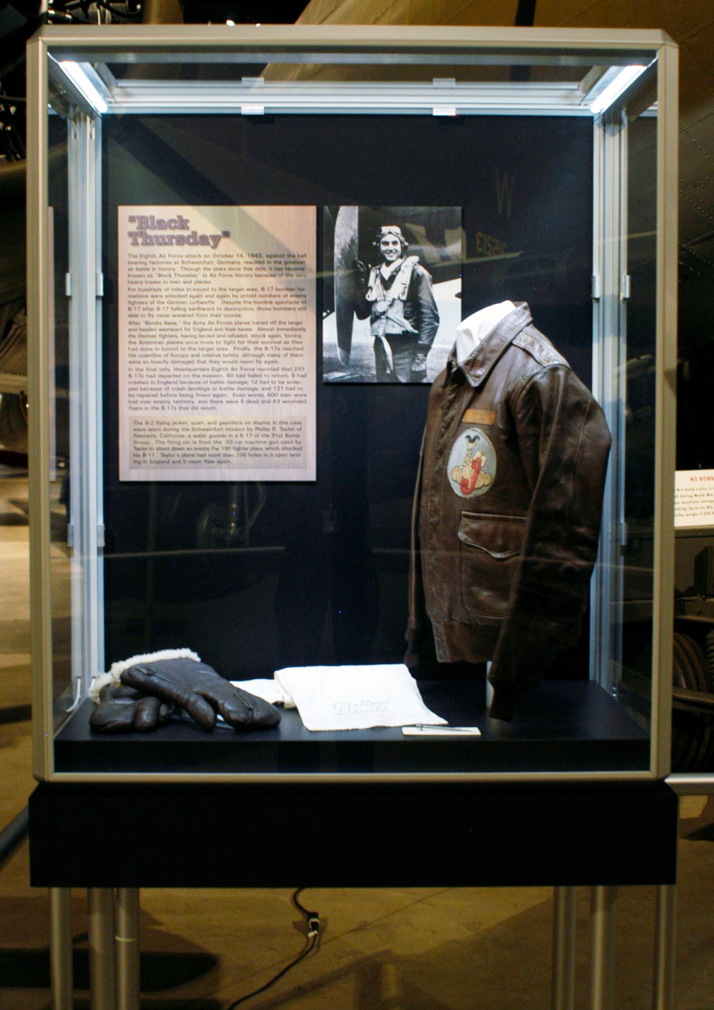 DAYTON, Ohio -- "Black Thursday" exhibit in the World War II Gallery at the National Museum of the U.S. Air Force. The A-2 flying jacket, scarf and gauntlets on display were during the Schweinfurt mission worn by Phillip R. Taylor of Alameda, Calif., a waist gunner in a B-17 of the 91st Bomb Group. The firing pin is from the .50-cal. machine gun used by Taylor to shoot down an enemy Fw 190 fighter plane that attacked his B-17. Taylor's plane had more than 200 holes in it upon landing in England, and it never flew again. (U.S. Air Force photo)   