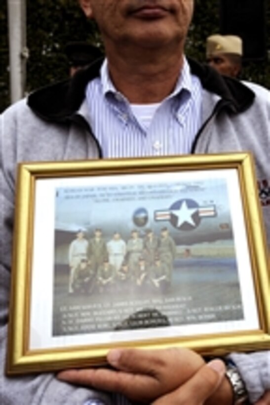 An audience member holds a photo of the 91st Strategic Reconnaissance Squadron including his uncle during the National POW/MIA Recognition Day Ceremony at the Pentagon on Sept. 18, 2009.  His uncle and the entire squadron were shot down during the Korean War in June 1952.  
