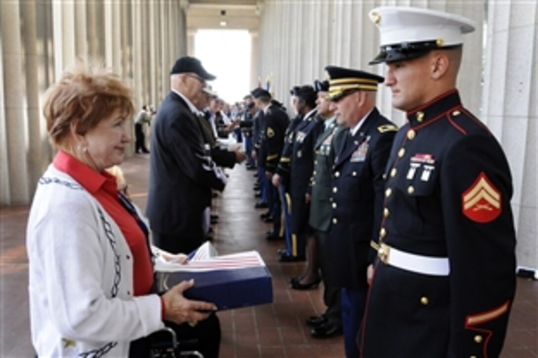 Medal of Honor recipients receive a flag from their military escorts before the opening ceremony of the Medal of Honor Convention at Soldier Field, Chicago, Sept. 15, 2009.  The flags had been previously flown over Soldier Field on the anniversary of the date they received the Medal of Honor.