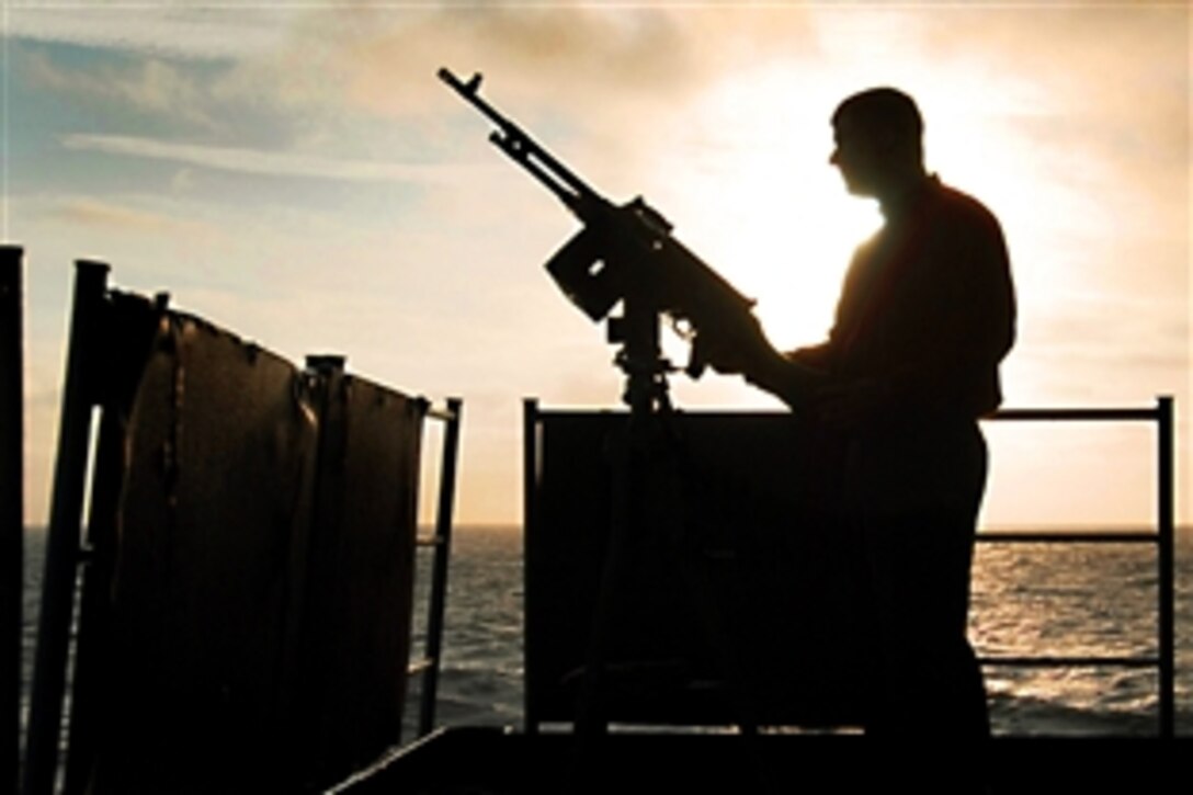 U.S. Navy Petty Office 1st Class Jason May readies an M-240 machine gun before a qualification shoot on the fantail of the aircraft carrier USS John C. Stennis, Sept. 15, 2009, in the Pacific Ocean. The Stennis is in transit to Southern California to participate in fleet-replacement carrier qualifications.