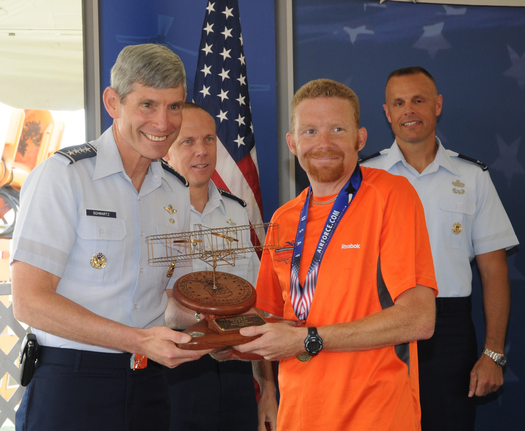 Gen. Norton Schwartz, Air Force Chief of Staff, gives a trophy to Dave Johnston, the male winner of the full marathon.  (US Air Force photo by Al Bright)
