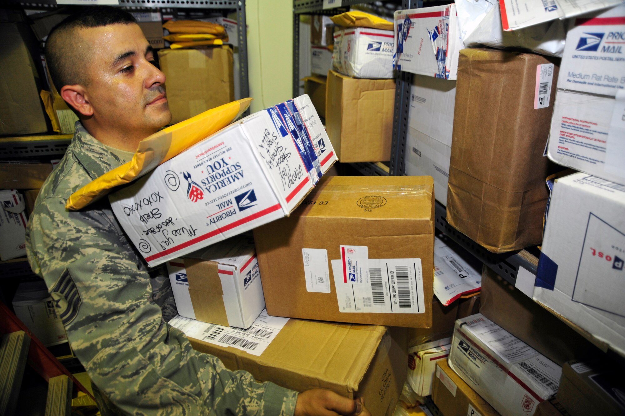 SOUTHWEST ASIA -Tech. Sgt. Brian Archuleta, 380th Expeditionary Communications Squadron, carries parcels to the fully stocked shelves Sept. 17, 2009. Sergeant Archuleta is deployed from Cannon Air Force Base, N.M., and hails from Las Vegas, Nev. (U.S. Air Force photo/Tech. Sgt. Charles Larkin Sr)
