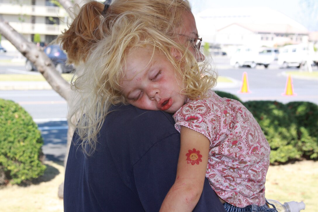 A young girl crashes after an exhausting day of fun at the Boys and Girls Club Day located on the parade deck in front of Building 1 on Sept. 19.