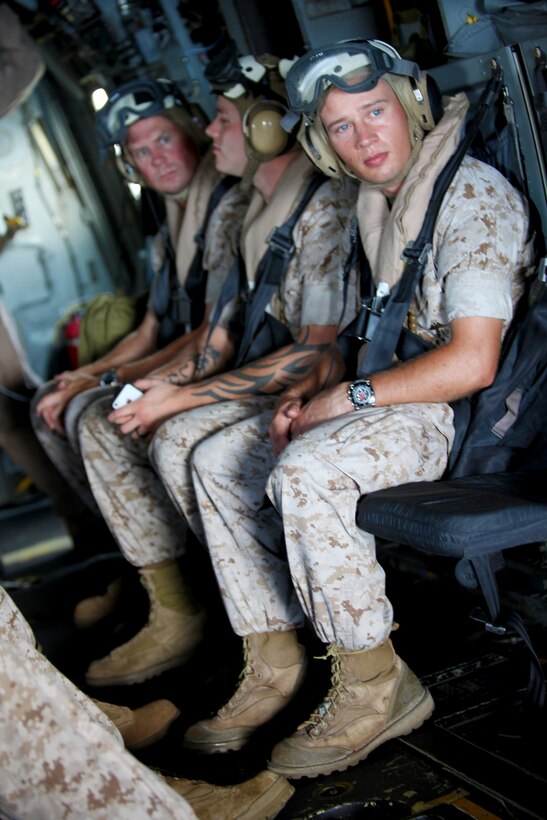26th Marine Expeditionary Unit Marines and sailors look out the back of a MV-22B Osprey during a flight over Marine Corps Air Station New River, N.C., Aug. 10, 2011. The visit was hosted by Marine Medium Tiltrotor Squadron 266 for the 26th MEU Command Element to get a better understanding of the 26th MEU's future Aviation Combat Element's capabilities. (U.S. Marine Corps photo by Cpl. Christopher Stone/Released)