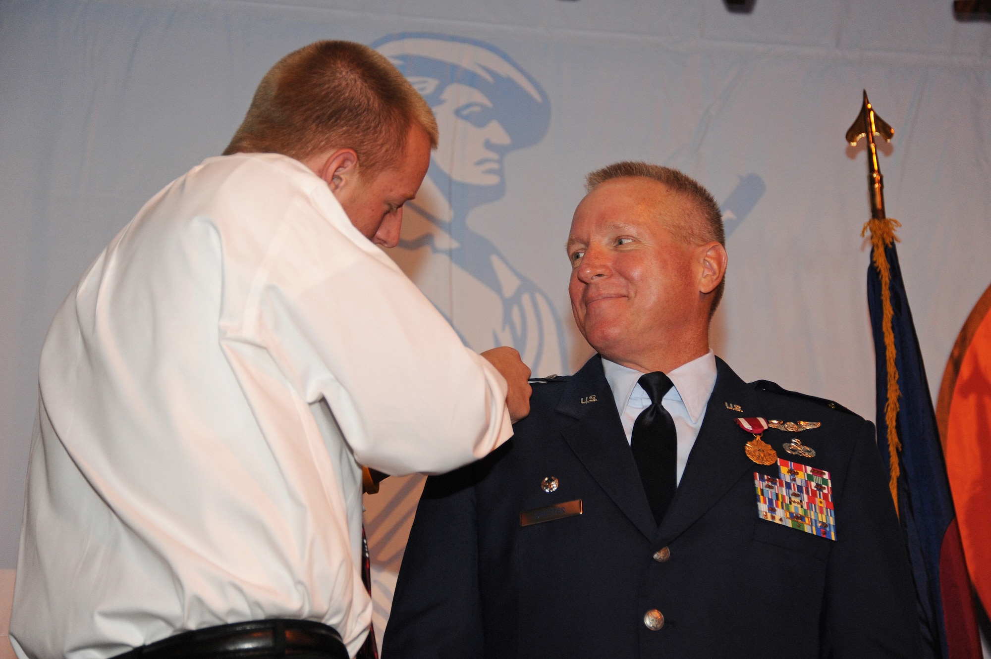 Colonel Thomas Shetter, Commander of the 140th Maintenance Group, watches his son attach his new rank to his dress uniform September 19, 2009 Buckley Air Force Base, CO.  Shetter was promoted to the rank of Colonel after 24 years of dedicated leadership. (U.S. Air Force photo by Tech Sgt. Wolfram M. Stumpf, Colorado Air National Guard/Released)