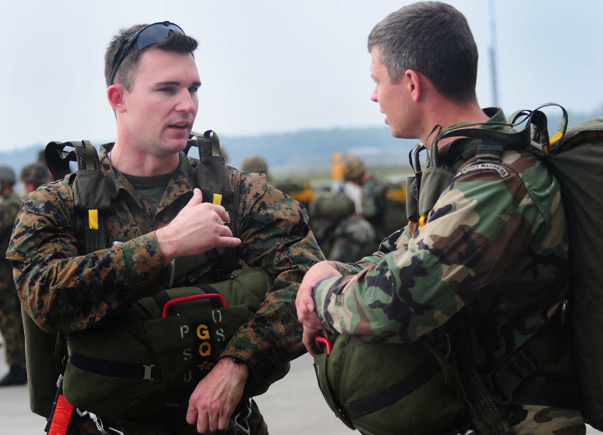 U.S. Marine Capt. Ben Michaels talks with a Royal Dutch Marine before they board an aircraft to jump with military members of six countries to commemorate the 65th anniversary of Operation Market Garden, in Arnhem, Holland.  Captain Michaels, a native of Dallas, Texas, is a part of an exchange program with the Royal Dutch Marines.  He will be receiving his British Royal Marine Airborne wings with this jump Sept 19, 2009. (U.S. Air Force Photo by Staff Sgt. Jocelyn Rich)