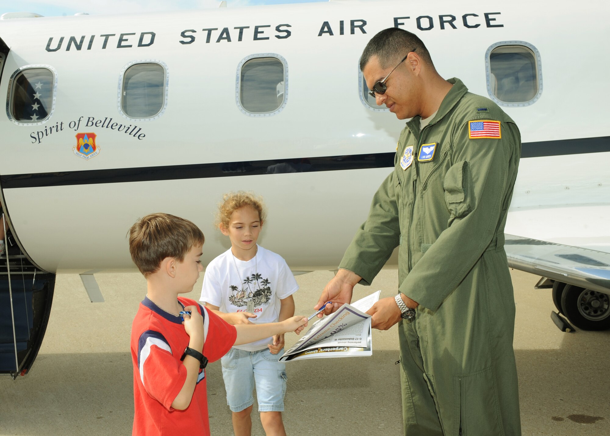 SCOTT AIR FORCE BASE, Ill. -- First Lt. Luis Garces, a C-21 pilot from the 458th Airlift Squadron, hands his autograph to David Jones from Scott during the Airpower Over the Midwest Airshow at Scott Saturday. (U.S. Air Force photo//Tech. Sgt. Michelle R. Larche)