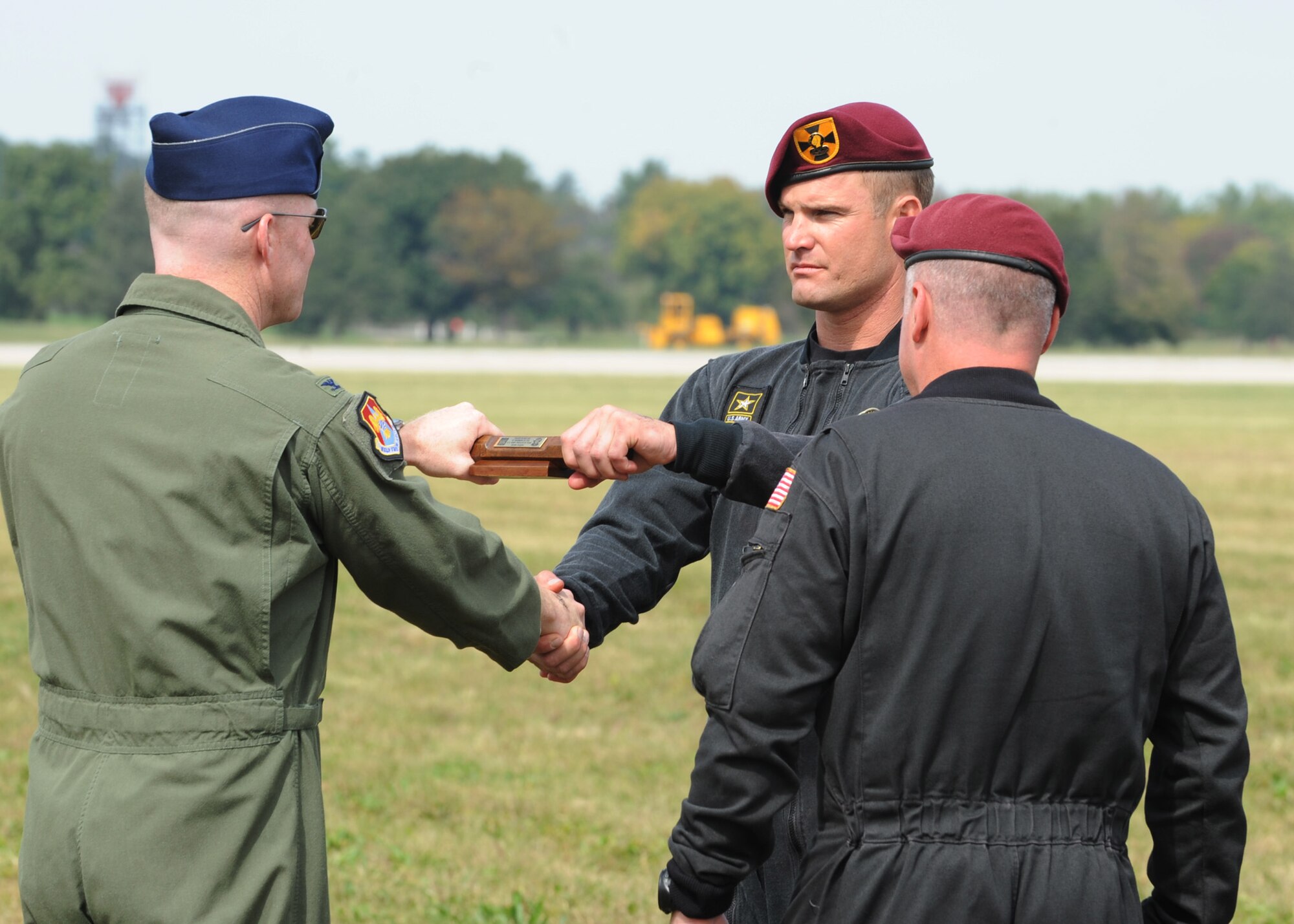 SCOTT AIR FORCE BASE, Ill. -- A member of the U.S. Army Golden Knights presents Col. Gary Goldstone, 375th Airlift Wing commander, with a baton after carrying it down with him during their parachute jump at the Air Power over the Midwest air show on Scott, Saturday. (U.S. Air Force photo/Airman 1st Class Wesley P. Farnsworth)