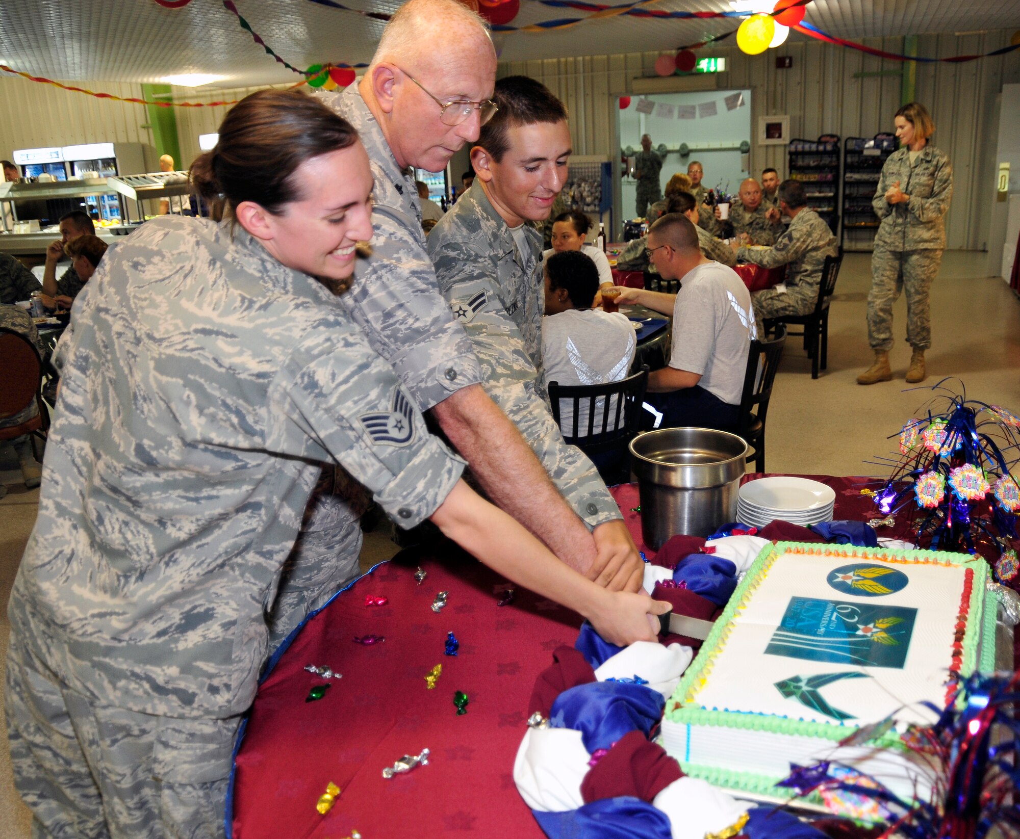 SOUTHWEST ASIA – Staff Sgt. Katie Kruis, Chaplain (Lt. Col.) Gary Breig and Airman 1st Class Jeremy Breznai, members of the 380th Air Expeditionary Wing, cut the Air Force birthday cake Sept. 18, 2009. The 380th AEW celebrated the 62nd anniversary of the Air Force as an independent branch of the military. (U.S. Air Force photo/Tech. Sgt. Charles Larkin Sr)

