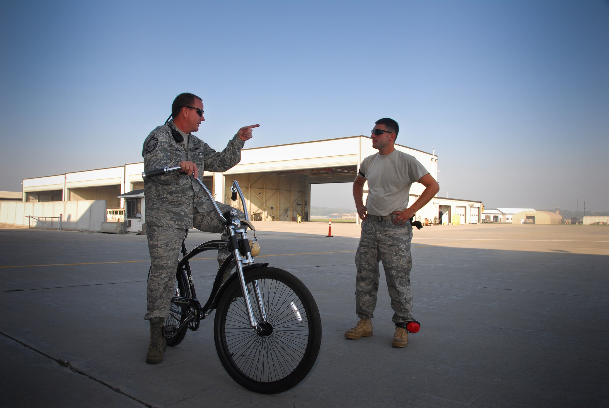 Senior Master Sgt. Al Dickrell and Tech Sgt. David Byzefski, F-16 crew chiefs with the 115th Aircraft Maintenance Squadron, discuss fl ightline operations. Sergeant Dickrell, a crew chief supervisor, sits atop a custom bike he personally bought to communicate with crew chiefs working the flightline here.