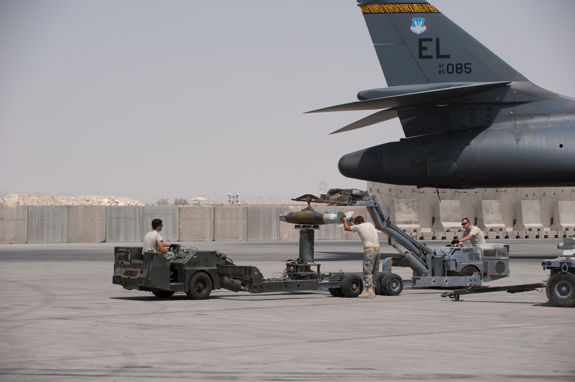 Left to right, Senior Airman Adam Weaver and Airmen 1st Class Brian Adkins and Andrew Peppin, 37th Expeditionary Aircraft Maintenance Unit weapons load crew members, transfer a GBU-38 from a MHU-83 bomb lift truck to a MJ-40 BLT prior to it being loaded into a B-1B Lancer, Sept. 16, in Southwest Asia. Carrying the largest payload of both guided and unguided weapons in the Air Force inventory, the multi-mission B-1 is the backbone of America's long-range bomber force --it can rapidly deliver massive quantities of precision and non-precision weapons against any adversary, anywhere in the world, at any time. Airmen Weaver, Adkins and Peppin are deployed from Ellsworth Air Force Base, S.D. in support of Operations Iraqi and Enduring Freedom. (U.S. Air Force photo/Staff Sgt. Robert Barney) 