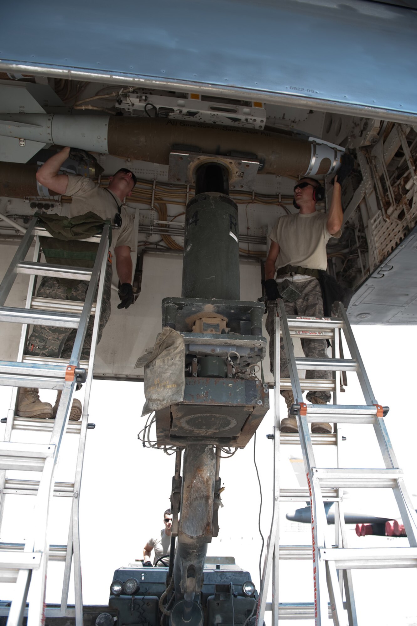 Left, Senior Airman Clayton Whitaker and Staff Sgt. Matthew Timm, 37th Expeditionary Aircraft Maintenance Unit weapons load crew members, secure a GBU-38 onto a B-1B Lancer, Sept. 16, in Southwest Asia. The 37 EAMU weapons flight loaded mission-specific payloads for a B-1 sortie in the U.S. Central Command's area of responsibility. Airman Whitaker and Sergeant Timm are both deployed from Ellsworth Air Force Base, S.D. in support of Operations Iraqi and Enduring Freedom. (U.S. Air Force photo/Staff Sgt. Robert Barney) 
