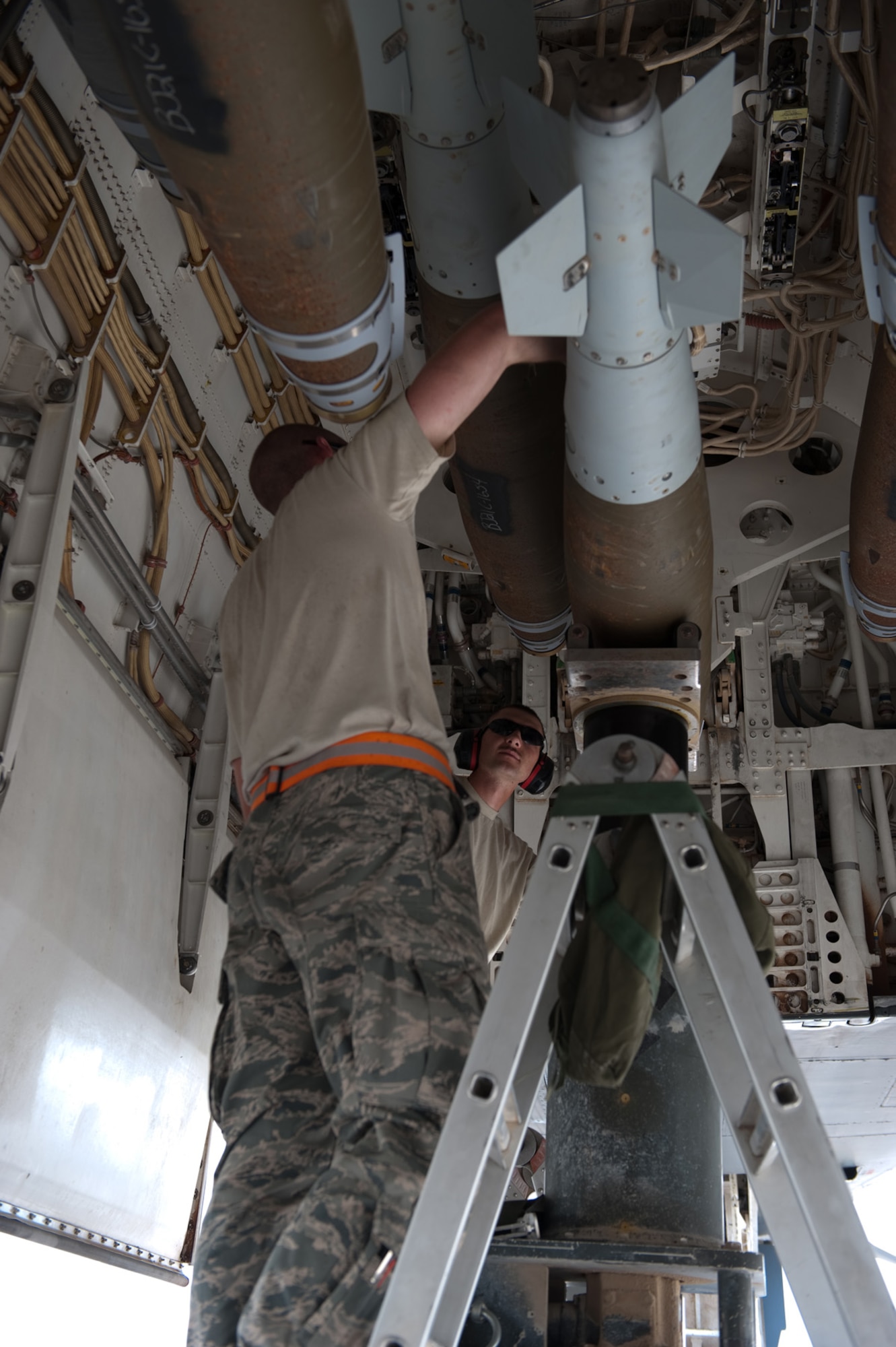Front, Senior Airman Clayton Whitaker and Staff Sgt. Matthew Timm, 37th Expeditionary Aircraft Maintenance Unit weapons load crew members, secure a GBU-38 onto a B-1B Lancer, Sept. 16, in Southwest Asia. Carrying the largest payload of both guided and unguided weapons in the Air Force inventory, the multi-mission B-1 is the backbone of America's long-range bomber force. It can rapidly deliver massive quantities of precision and non-precision weapons against any adversary, anywhere in the world, at any time. Airman Whitaker and Sergeant Timm are deployed from Ellsworth Air Force Base, S.D. in support of Operations Iraqi and Enduring Freedom. (U.S. Air Force photo/Staff Sgt. Robert Barney) 