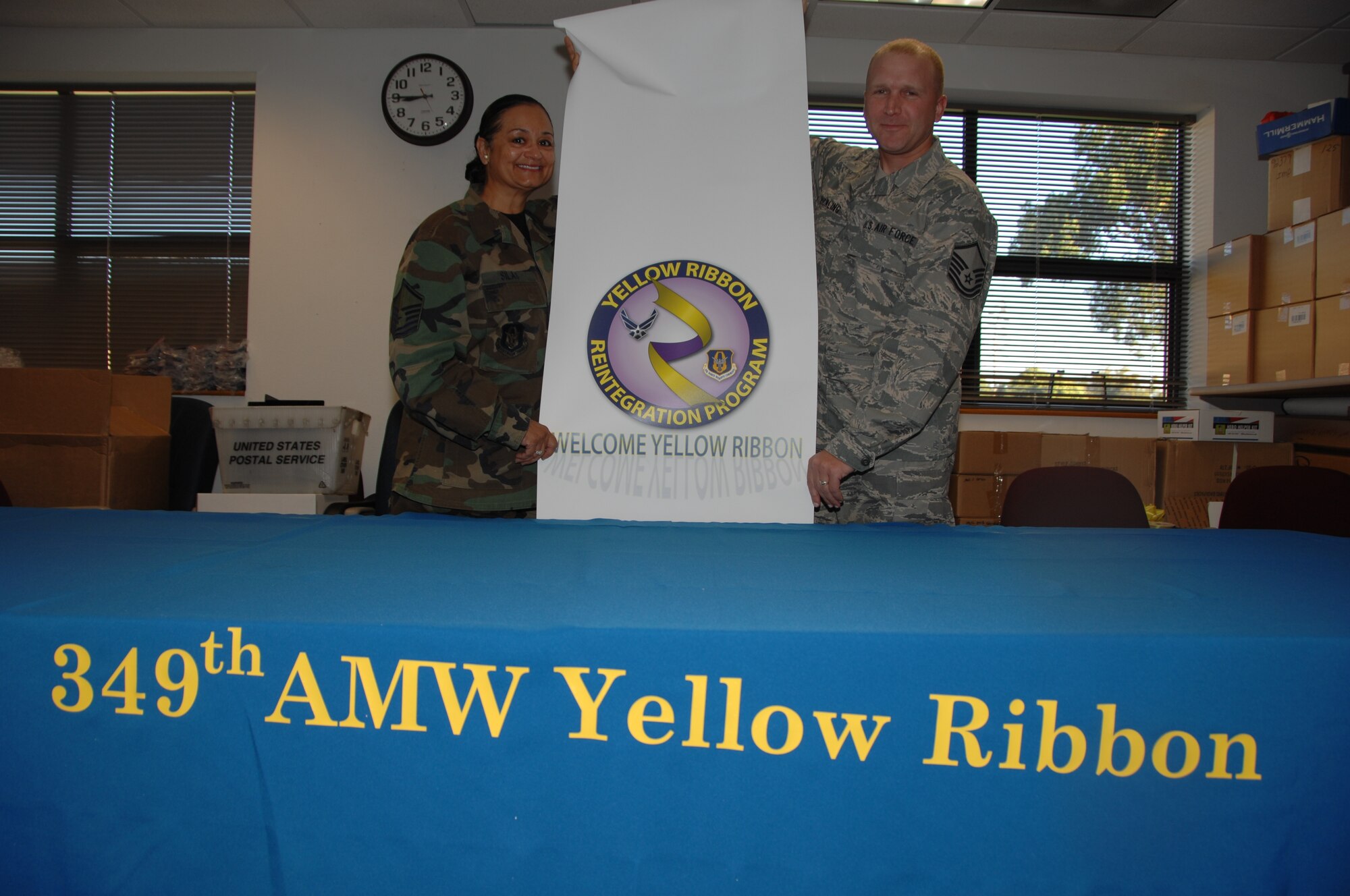 TRAVIS AIR FORCE BASE, Calif. -- Master Sgts. Pam Silas and Heath Rickling, 349th Air Mobility Wing Family Readiness, roll out the banner in preparation for the Sept. 26 Yellow Ribbon Reintegration Dinner and festivities. The events will be opened at Noon by Wing Commander, Brig. Gen. Maryanne Miller, and include briefings for families, games and activities for children, and finish up with a spaghetti dinner and town hall meeting with a question and answer session. For more information, contact Tech. Sgt. Teresa Grieff, Master Sgt. Pam Silas, or Mr. Jack Watts, Family Readiness, 707-424-1616, or via email. (U.S. Air Force photo/Senior Master Sgt. Ellen Hatfield)  