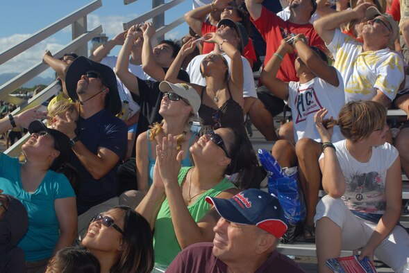 HICKAM AIR FORCE BASE, Hawaii -- Audience members look on as the Thunderbirds, U.S. Air Force Air Demonstration Squadron, perform combat maneuvers during the Open House, "Wings over the Pacific," here, Sep. 19. The Open House featured live band performances, static displays and The Thunderbirds demonstrated the capabilities of the F-16 Fighting Falcon. Over 99,000 people attended the two day event. (U.S. Air Force photo/Senior Airman Gustavo Gonzalez)