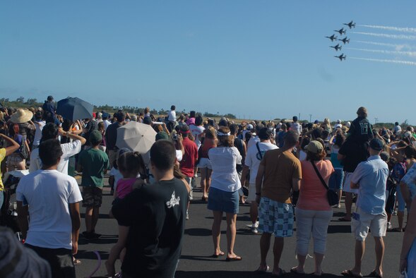 HICKAM AIR FORCE BASE, Hawaii -- Audience members look on as the Thunderbirds, U.S. Air Force Air Demonstration Squadron, perform combat maneuvers during the Open House, "Wings over the Pacific," here, Sep. 19. The Open House featured live band performances, static displays and The Thunderbirds demonstrated the capabilities of the F-16 Fighting Falcon. Over 99,000 people attended the two day event. (U.S. Air Force photo/Senior Airman Gustavo Gonzalez)