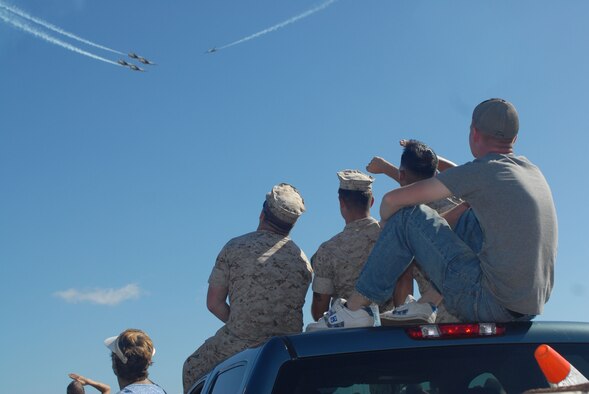 HICKAM AIR FORCE BASE, Hawaii -- Marines from Marine Corps Base Hawaii, Kaneohe Bay, look on as the Thunderbirds, U.S. Air Force Air Demonstration Squadron, perform combat maneuvers during the Open House, "Wings over the Pacific," here, Sep. 19. The Open House featured live band performances, static displays and The Thunderbirds demonstrated the capabilities of the F-16 Fighting Falcon. Over 99,000 people attended the two day event. (U.S. Air Force photo/Senior Airman Gustavo Gonzalez)