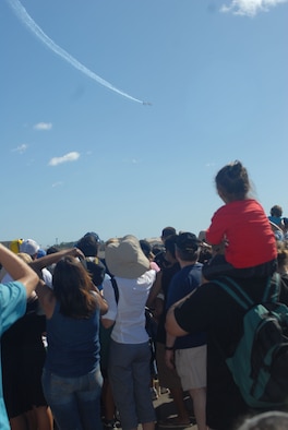 HICKAM AIR FORCE BASE, Hawaii -- Audience members look on as the Thunderbirds, U.S. Air Force Air Demonstration Squadron, perform combat maneuvers during the Open House, "Wings over the Pacific," here, Sep. 19. The Open House featured live band performances, static displays and The Thunderbirds demonstrated the capabilities of the F-16 Fighting Falcon. Over 99,000 people attended the two day event. (U.S. Air Force photo/Senior Airman Gustavo Gonzalez)