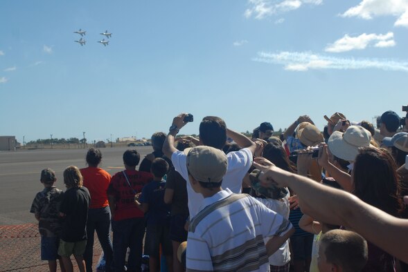 HICKAM AIR FORCE BASE, Hawaii -- Audience members look on as the Thunderbirds, U.S. Air Force Air Demonstration Squadron, perform combat maneuvers during the Open House, "Wings over the Pacific," here, Sep. 19. The Open House featured live band performances, static displays and The Thunderbirds demonstrated the capabilities of the F-16 Fighting Falcon. Over 99,000 people attended the two day event. (U.S. Air Force photo/Senior Airman Gustavo Gonzalez)