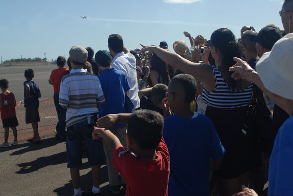 HICKAM AIR FORCE BASE, Hawaii -- Audience members look on as the Thunderbirds, U.S. Air Force Air Demonstration Squadron, perform combat maneuvers during the Open House, "Wings over the Pacific," here, Sep. 19. The Open House featured live band performances, static displays and The Thunderbirds demonstrated the capabilities of the F-16 Fighting Falcon. Over 99,000 people attended the two day event. (U.S. Air Force photo/Senior Airman Gustavo Gonzalez)