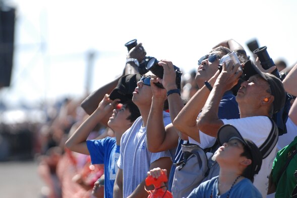 HICKAM AIR FORCE BASE, Hawaii -- Audience members look on as the Thunderbirds, U.S. Air Force Air Demonstration Squadron, perform combat maneuvers during the Open House, "Wings over the Pacific," here, Sep. 19. The Open House featured live band performances, static displays and The Thunderbirds demonstrated the capabilities of the F-16 Fighting Falcon. Over 99,000 people attended the two day event. (U.S. Air Force photo/Senior Airman Gustavo Gonzalez)