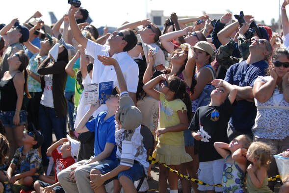 HICKAM AIR FORCE BASE, Hawaii -- Audience members look on as the Thunderbirds, U.S. Air Force Air Demonstration Squadron, perform combat maneuvers during the Open House, "Wings over the Pacific," here, Sep. 19. The Open House featured live band performances, static displays and The Thunderbirds demonstrated the capabilities of the F-16 Fighting Falcon. Over 99,000 people attended the two day event. (U.S. Air Force photo/Senior Airman Gustavo Gonzalez)
