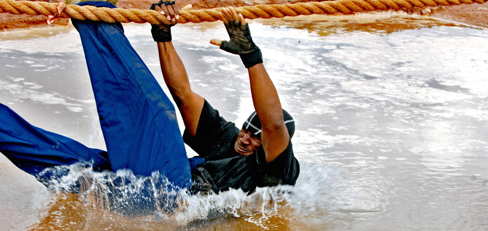 HOLLOMAN AIR FORCE BASE, N.M. -- Senior Airman Phiilip Warren, 49th Logistics Readiness Squadron, takes a dive into muddy waters as his team loses in the tug of war event during Wing Sports Day at the Domenici Fitness and Sports Center here Sept. 18. Members from 16 squadrons competed in a variety of sports while spectators observed and rooted for their colleagues during the morale-boosting event.(U.S. Air Force photo by Staff Sgt. Anthony Nelson Jr.)