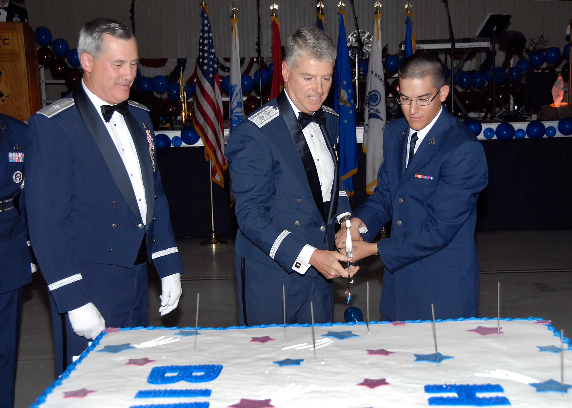 Brig. Gen. O.G. Mannon, 82nd Training Wing commander, presents Maj. Gen Anthony F. Przybyslawski, Headquarters Air Education and Training Command vice commander, with a ceremonial sword to cut the 62nd Air Force birthday cake with. Gen. Przybyslawski and the most junior enlisted member at Sheppard, Airman Carlos Vargas, 364th Training Squadron, cut the cake together to symbolize the passing of the torch. (U.S. Air Force photo/ Harry Tonemah)
