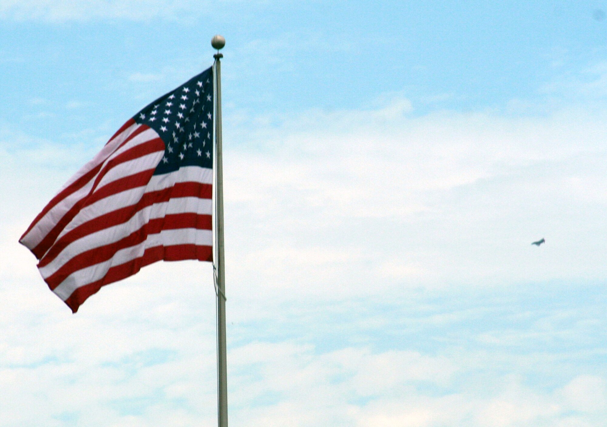 A vintage F-4 Phantom II aircraft flies in the background of the American flag during the 2009 Scott Air Force Base Airshow on Sept. 19, 2009, at Scott AFB, Ill.  The airshow drew tens of thousands of people and featured a wide variety of aircraft on static display and in aerial performances.  (U.S. Air Force Photo/Tech. Sgt. Scott T. Sturkol)
