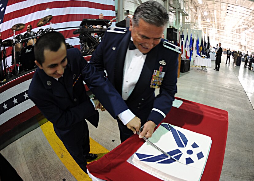 DYESS AIR FORCE BASE, Texas – Airman Basic Gerald Gregory, 7th Engineer Squadron, and Col. James Milburn, 7th Maintenance Squadron commander, the youngest and oldest active-duty Airmen attending the Air Force Hangar Dance, cut the cake here Sept. 18. Artifacts on display from ranged from World War II era to present day, with 7th Security Forces Squadron exhibiting the latest advanced war-fighting weapons. The dance was held to celebrate the 62nd birthday of the Air Force with more than 425 guests. (U.S. Air Force photo by Senior Airman Jennifer Romig)