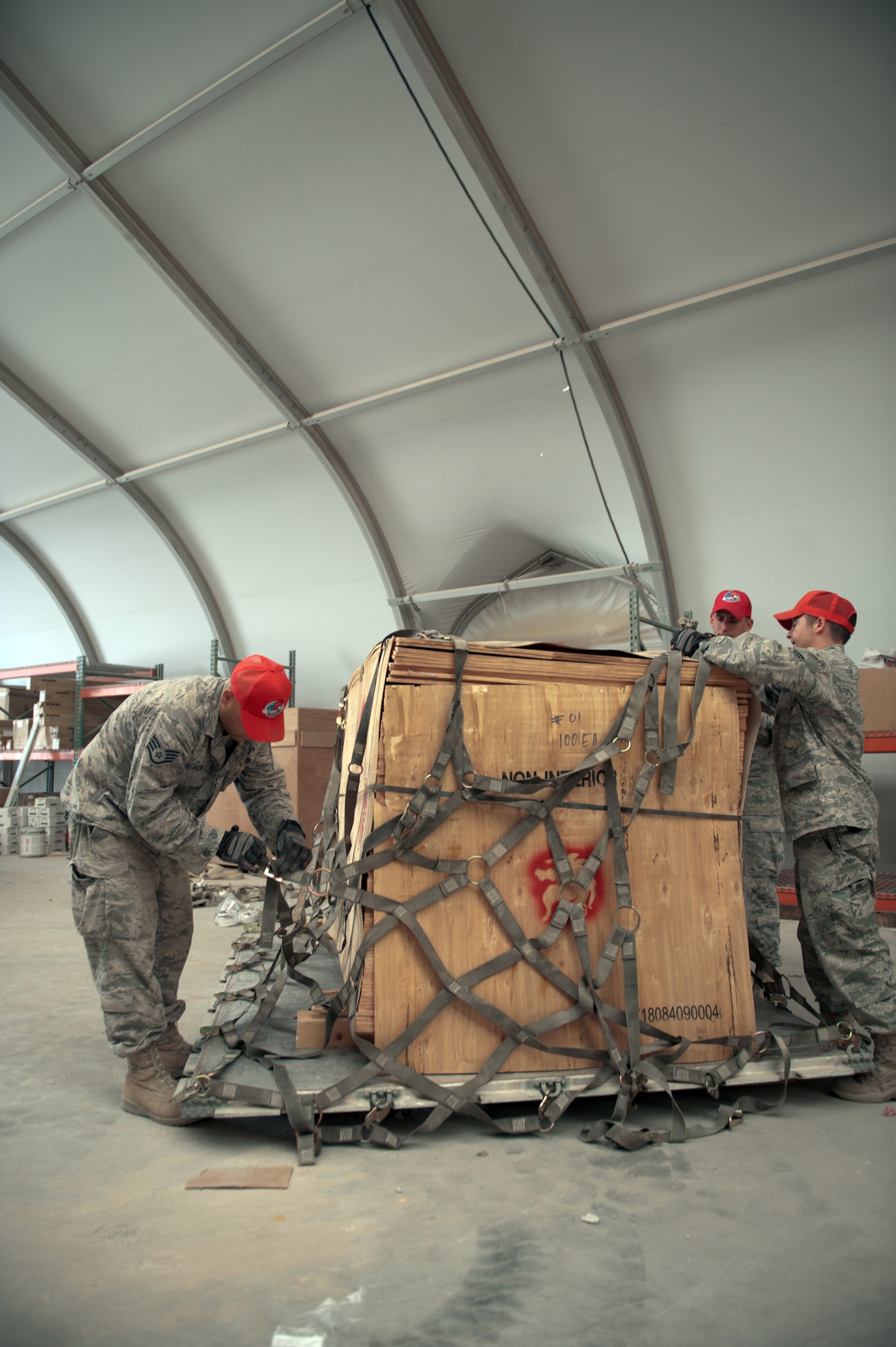 Airmen of the 1st Expeditionary RED HORSE Group logistics and pallet build-up team secure a pallet of wood to be shipped Sept. 15, 2009, at an air base in Southwest Asia. Personnel assigned to the logistics and pallet build-up team support all RED HORSE operations downrange by obtaining and shipping required equipment for mission success. (U.S. Air Force photo/Staff Sgt. Robert Barney) 