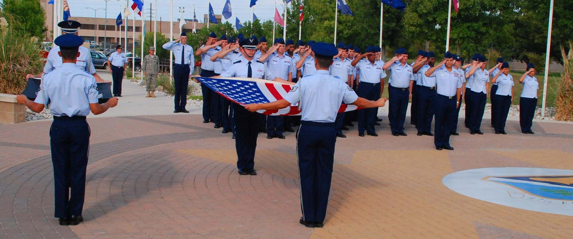 LAUGHLIN AIR FORCE BASE, Texas – Members of the Laughlin Honor Guard perform a flag-folding ceremony as a formation of Airmen commanded by Senior Master Sgt. John Maldonado, 47th Installation Support Squadron, looks on and salutes during the POW/MIA Remembrance ceremony here Sept. 18. The ceremony was held in observance of National POW/MIA Remembrance Day, which is held the third Friday in September as a way to remember former American prisoners of war and those still missing in action. (U.S. Air Force photo by Airman 1st Class Blake Mize)