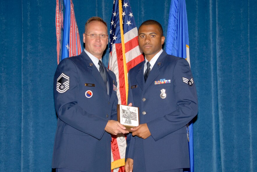 McGHEE TYSON AIR NATIONAL GUARD BASE, Tenn. -- Senior Airman Robert Moore, a security forces patrolman with the Air Force Reserves, Peterson Air Force Base, Colo., receives the Academic Achievement Award for Airman Leadership School Class 09-5 at The Air National Guard Training and Education Center here from Senior Master Sgt. Timothy Kumes, Sept. 10, 2009.  The Academic Achievement Award denotes excellence as a scholar.  It is based upon all summative objective tests and individual performance evaluations and is given to the student with the highest overall academic standing.   (U.S. Air Force photo by Master Sgt. Kurt Skoglund)