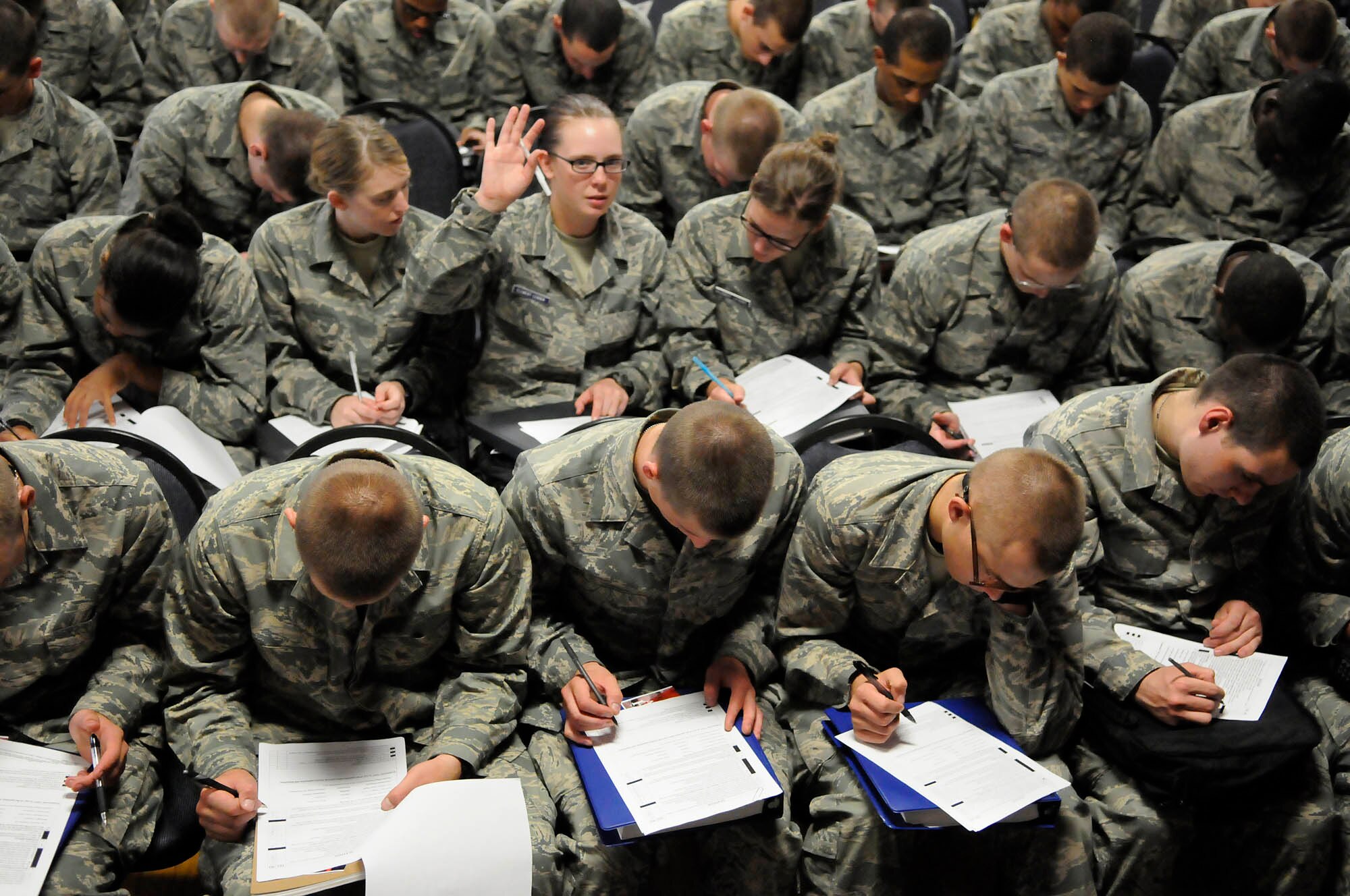 Brianna Johnson, a United States Air Force basic trainee, raises her hand to ask a question about how to fill out an application for the United States Air Force Honor Guard Sept. 19 at Lackland Air Force Base, Texas. Johnson and other trainees watched a performance by the Drill Team before being asked if they wanted to join the Honor Guard. The Drill Team along with members of the Honor Guard’s recruiting section travel to Lackland every other month in order to recruit new members into the Honor Guard. (U.S. Air Force photo by Staff Sgt. Dan DeCook)